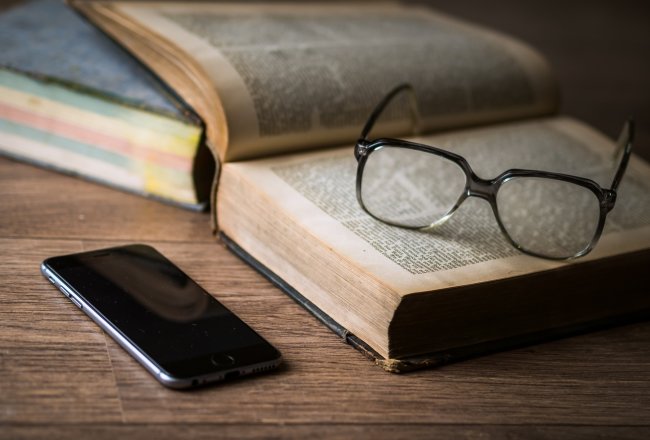 Glasses on book with phone generic