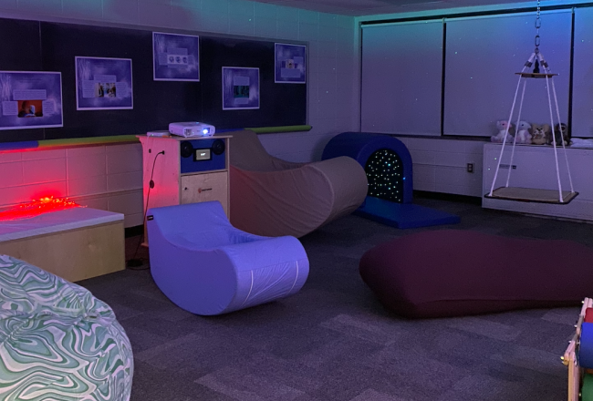 Low lighting and specialized chairs in the OT Sensory Room.