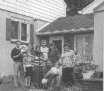 Black and White photo of Bosnian family outside a home.