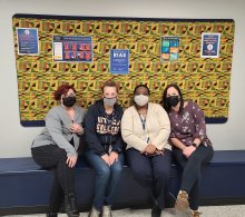 Students in front of Kenth cloth bulleting board.