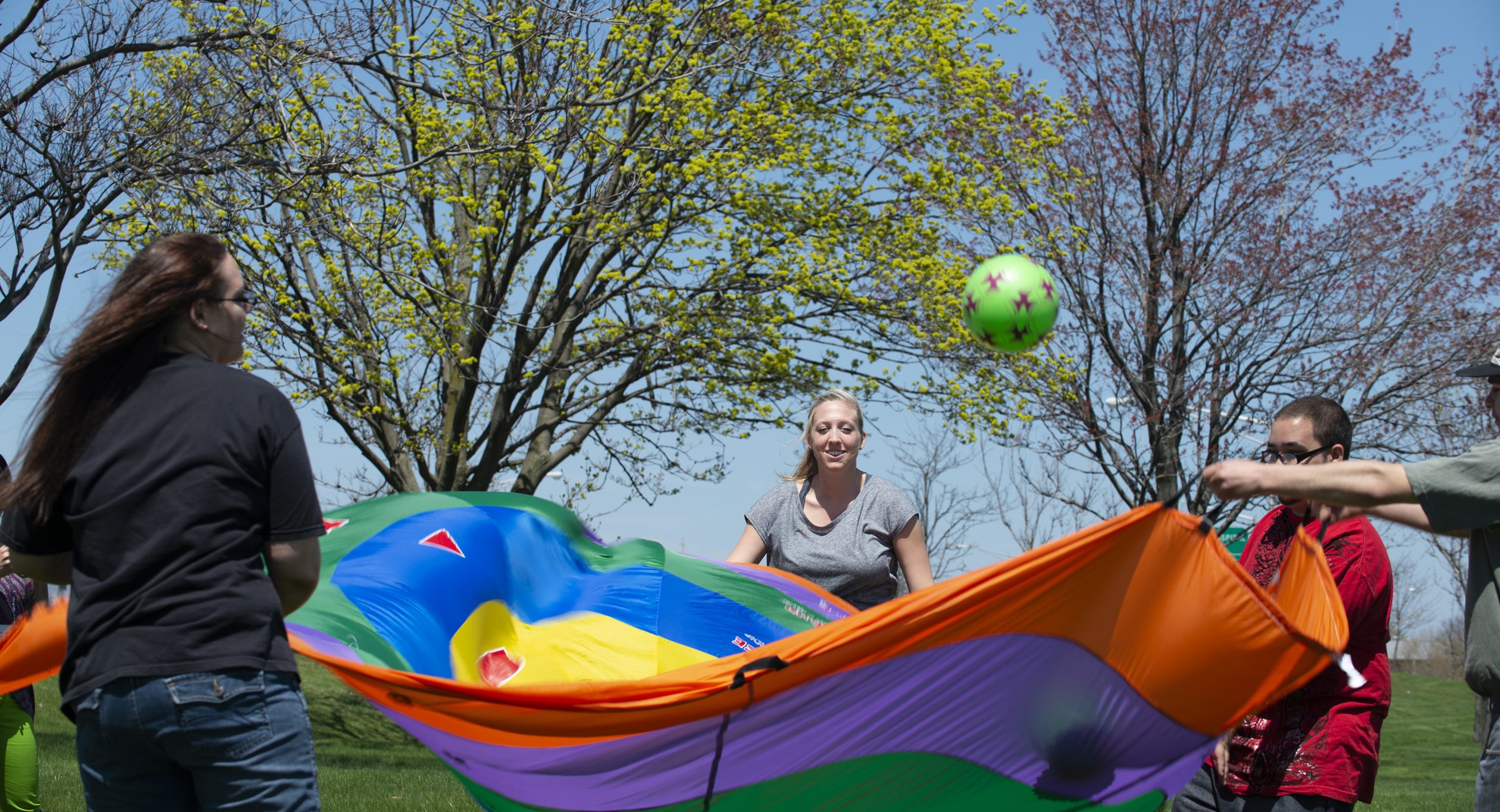 Occupational Therapy students at work with parachute and ball.