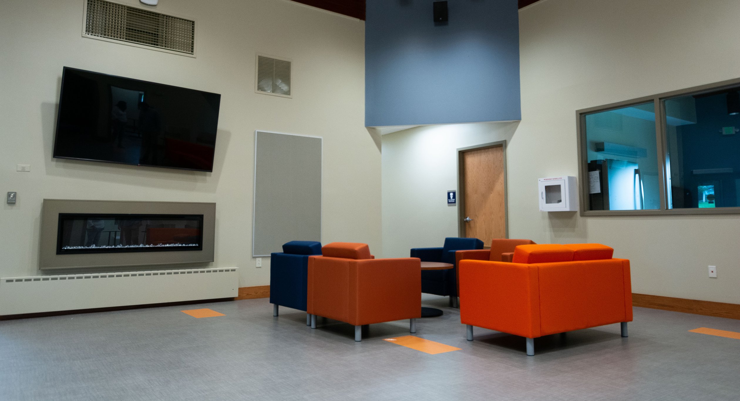 Chairs, fireplace, and television in the new Wilcox Center.