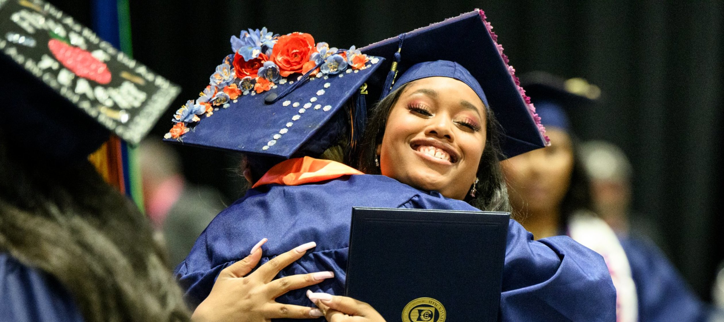 Graduates of the Class of 2022 hug at Commencement.