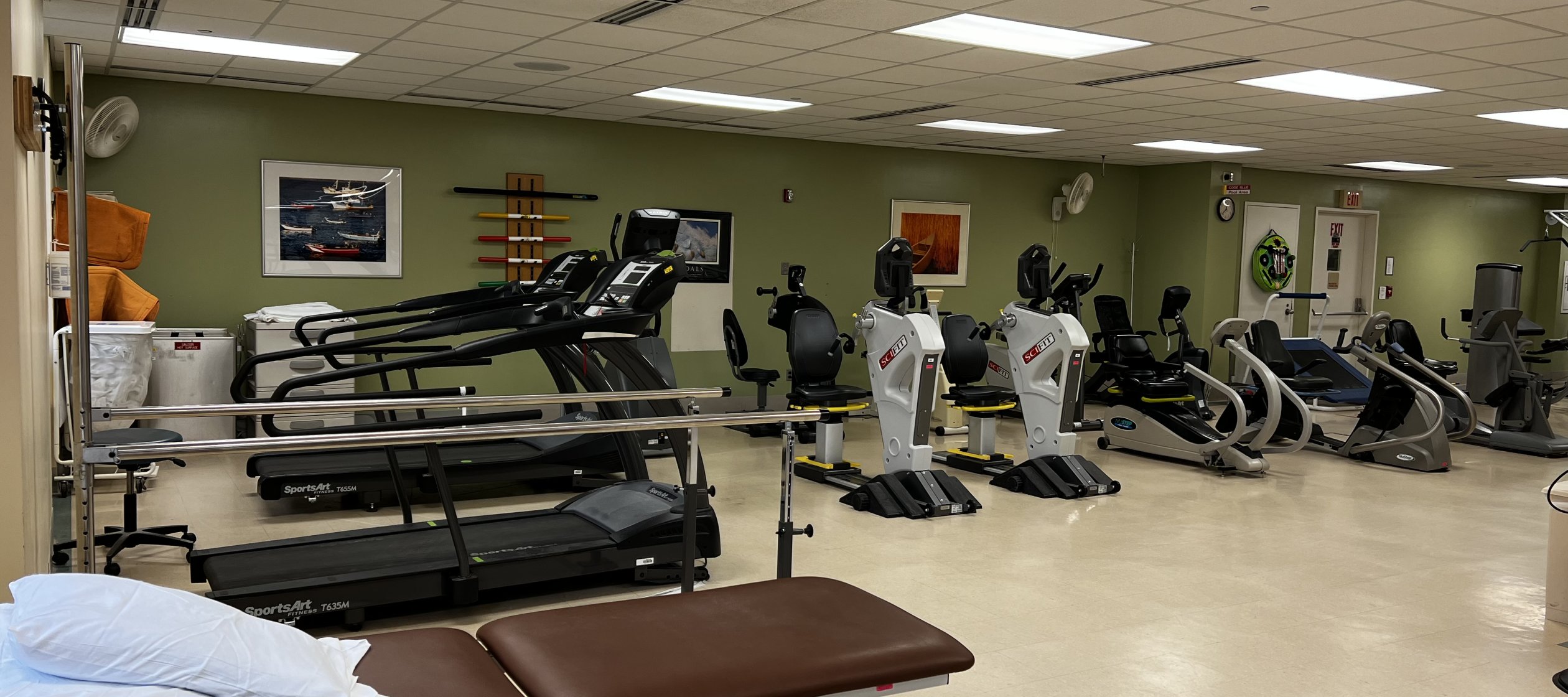 A room filled with gym equipment such as treadmills and stair machines used for orthapedic rehabilitation.