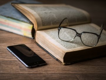 Glasses on book with phone generic