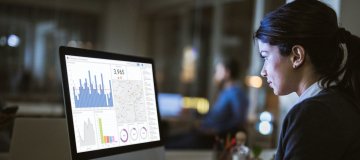 Woman lokoing at business data on computer screen.