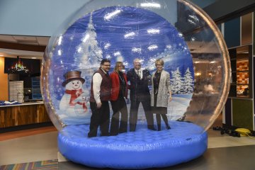 Members of University administration pose inside an inflatable snowglobe at 2022 Holiday Dinner.