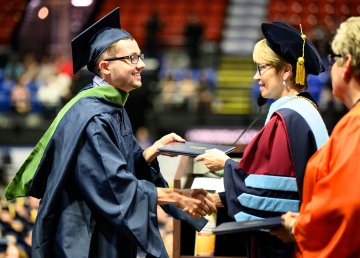 A gradute receives their diploma from President Laura Casamento during the 2022 Commencement ceremony.