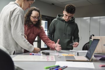 Jon Gaffney teaching Physics with students at a table.