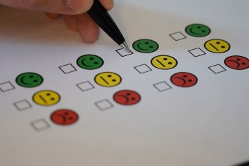 Pen about to mark off happy on a survey.