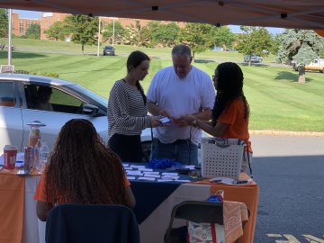 Father and daughter are assisted by current students with getting settled on campus.