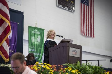 Provost Ann Damiano at the podium, speaking at Convocation 2026.