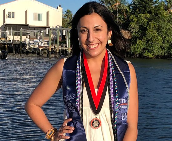 Kim Slezak '21 stands by the water following graduation from UC's ABSN program in Florida.
