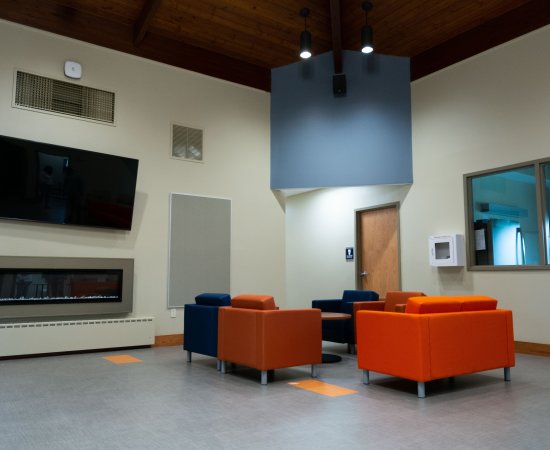Chairs, fireplace, and television in the new Wilcox Center.