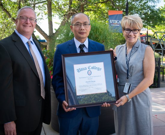 Harold T. Clark Jr. Endowed Professorship award winner Professor Zhadroan Jordan Huang stands with Provost Todd Pfannestiel and President Laura Casamento.