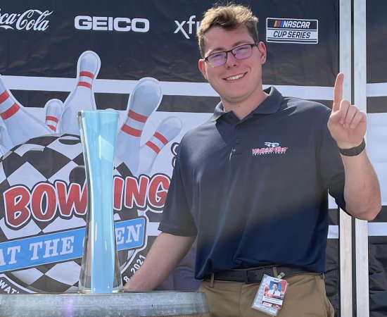 Robert Stevens '22 stands next to trophy at Watkins Glen international racetrack.