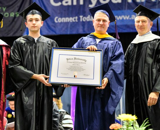 President Laura Casamento, Vasyl Yurkuts, Professor Maxim Gorbachevsky, and Chair of Utica University Board of Trustees Robert Brvenik accept honorary degree on behalf of Ukrainian President Volodymyr Zelenskyy.