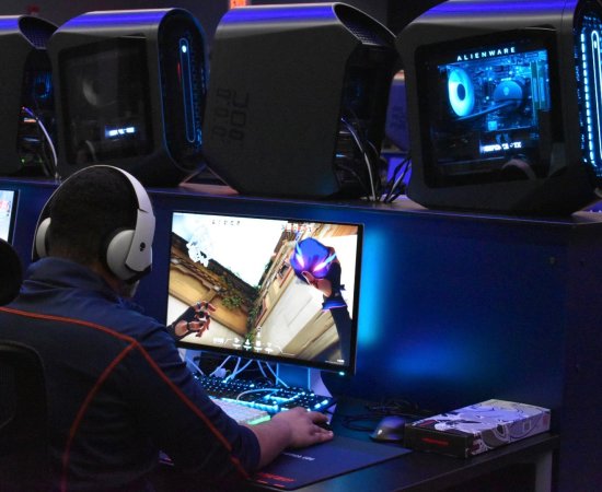 A student sits at a computer screen playing a game as part of Utica University's eSports program.