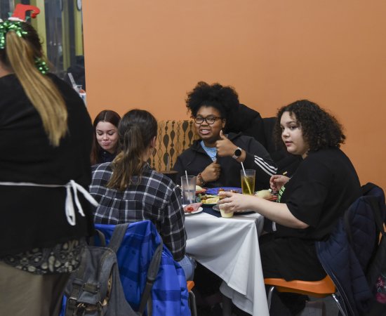 Student gives a thumbs up at the 2022 Holiday Dinner.
