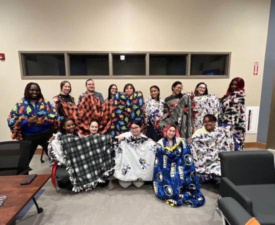 Members of the Title IX Team, Students, Faculty, and Staff show off Tie Blankets made to benefit domestic violence victims.