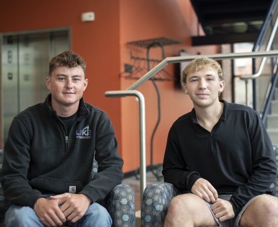 Evan Andrews ’27 and Thaddeus Luke ’27 sit on chairs. 