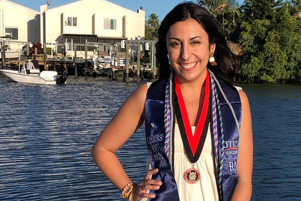 Kim Slezak '21 stands by the water following graduation from UC's ABSN program in Florida.