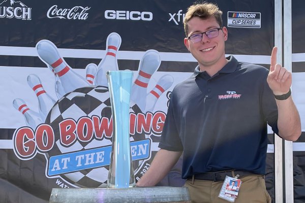 Robert Stevens '22 stands next to trophy at Watkins Glen international racetrack.