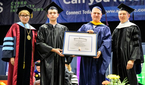 President Laura Casamento, Vasyl Yurkuts, Professor Maxim Gorbachevsky, and Chair of Utica University Board of Trustees Robert Brvenik accept honorary degree on behalf of Ukrainian President Volodymyr Zelenskyy.