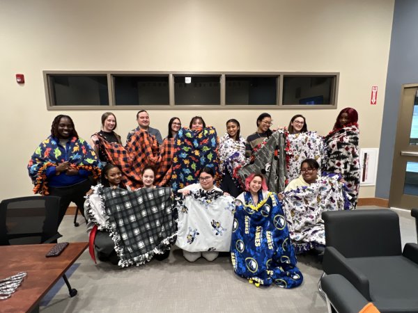Members of the Title IX Team, Students, Faculty, and Staff show off Tie Blankets made to benefit domestic violence victims.