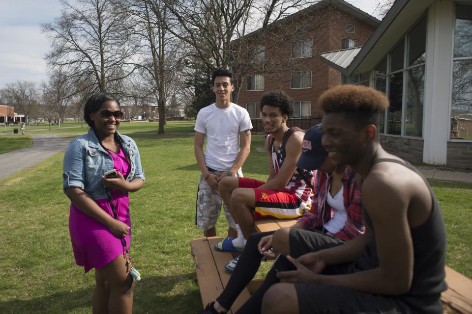 Students laughing at campus picnic tables in Spring 068