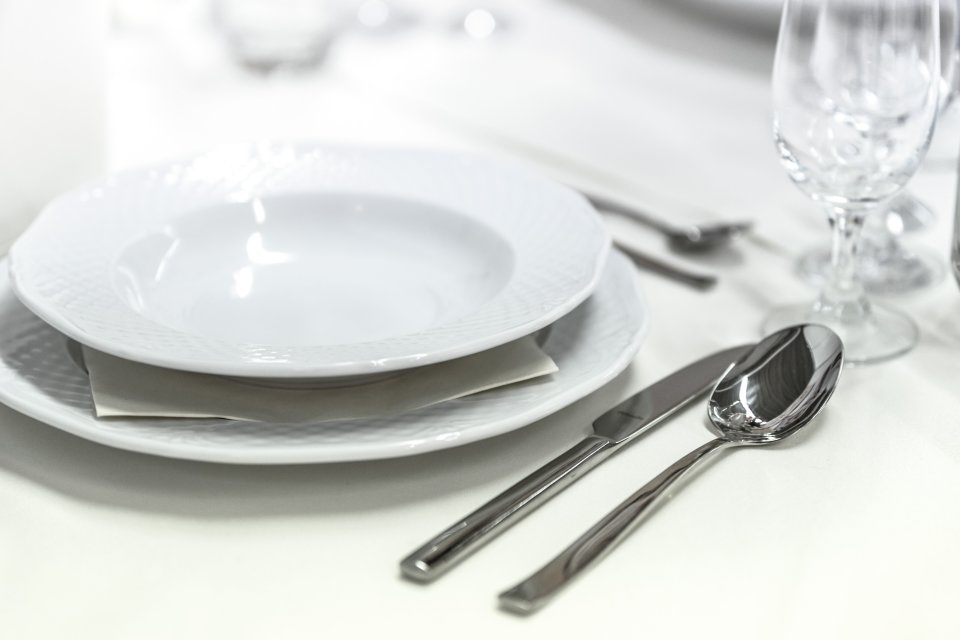 Plates and silverware on a well-set table.