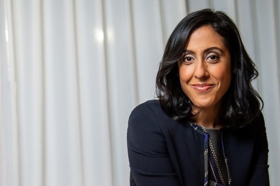 Image of Erica Dhawan against background of curtains.