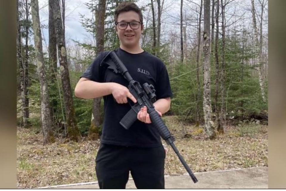 Kyle Rittenhouse poses holding an assault weapon.