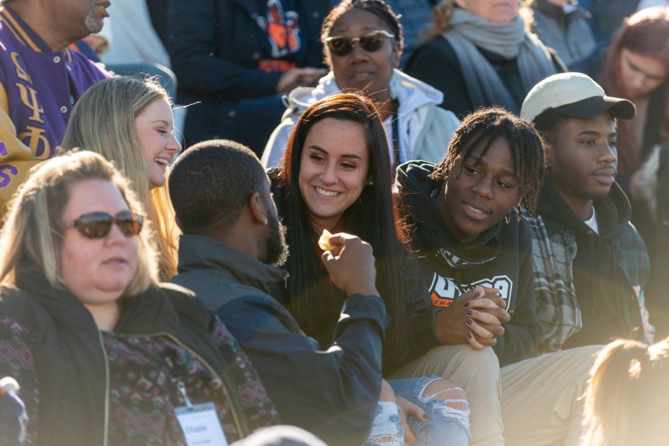 Homecoming crowd sitting in bleachers.