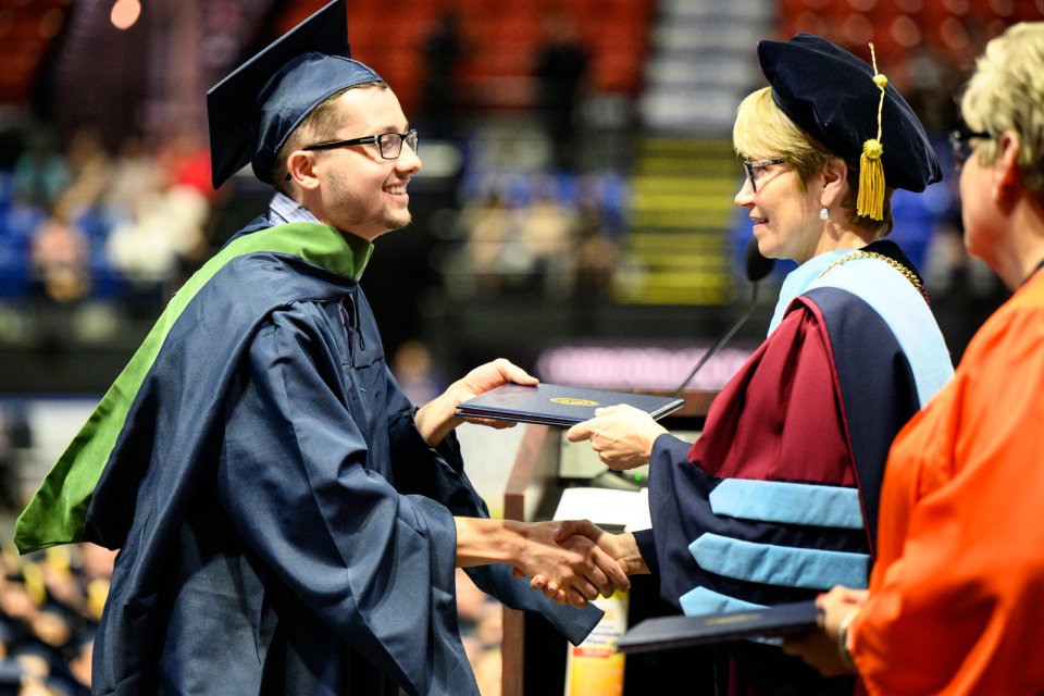 A gradute receives their diploma from President Laura Casamento during the 2022 Commencement ceremony.